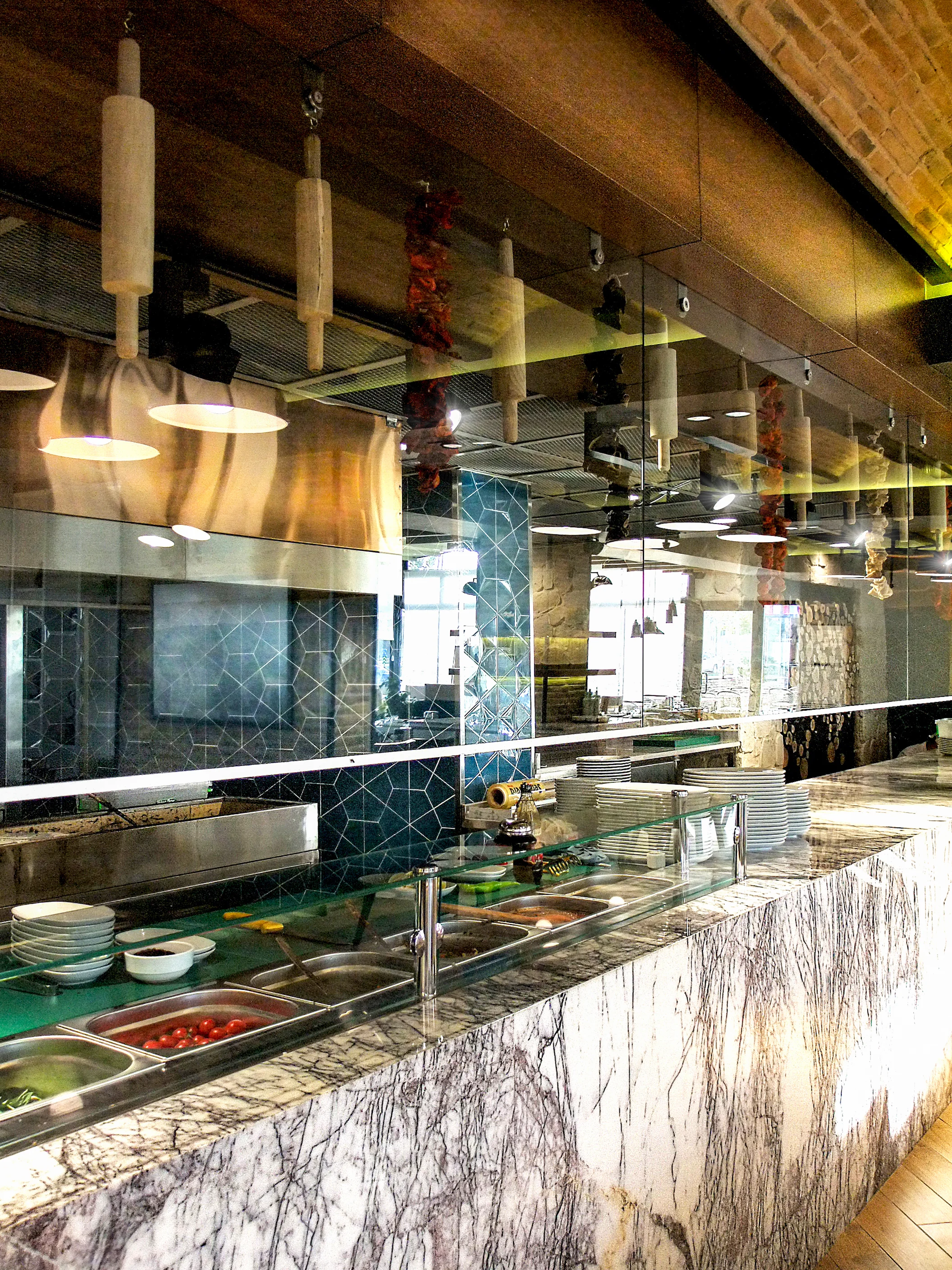 Fırın-ci 75 İlk Konsept restoran iç mekânında tuğla tavan, ahşap banko, açık mutfak ve modern yeme-içme alanı tasarımı.