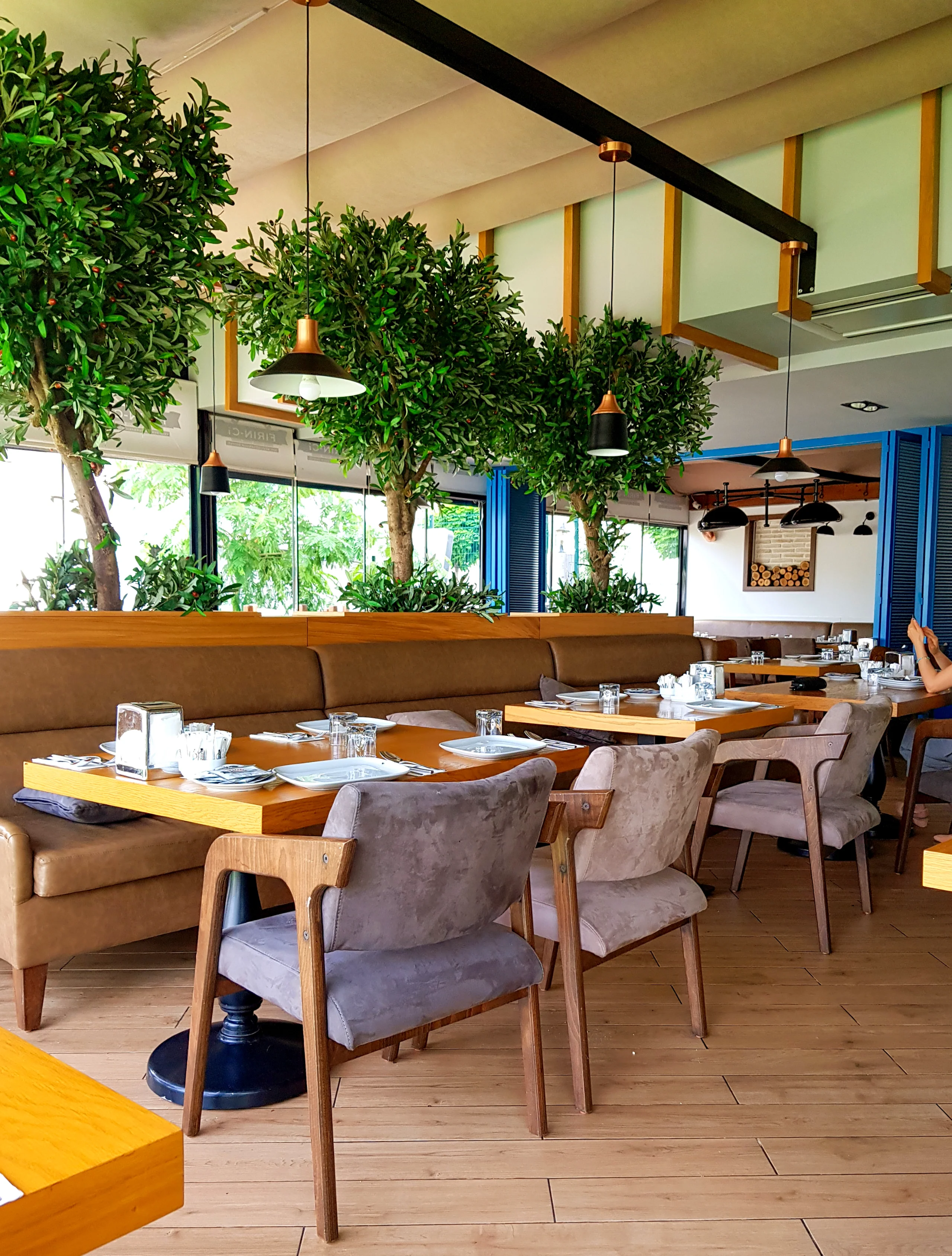 Fırın-ci 75 İlk Konsept restoranında tuğla kolon, desenli zemin, ahşap masa ve sıcak iç mekân tasarımı.