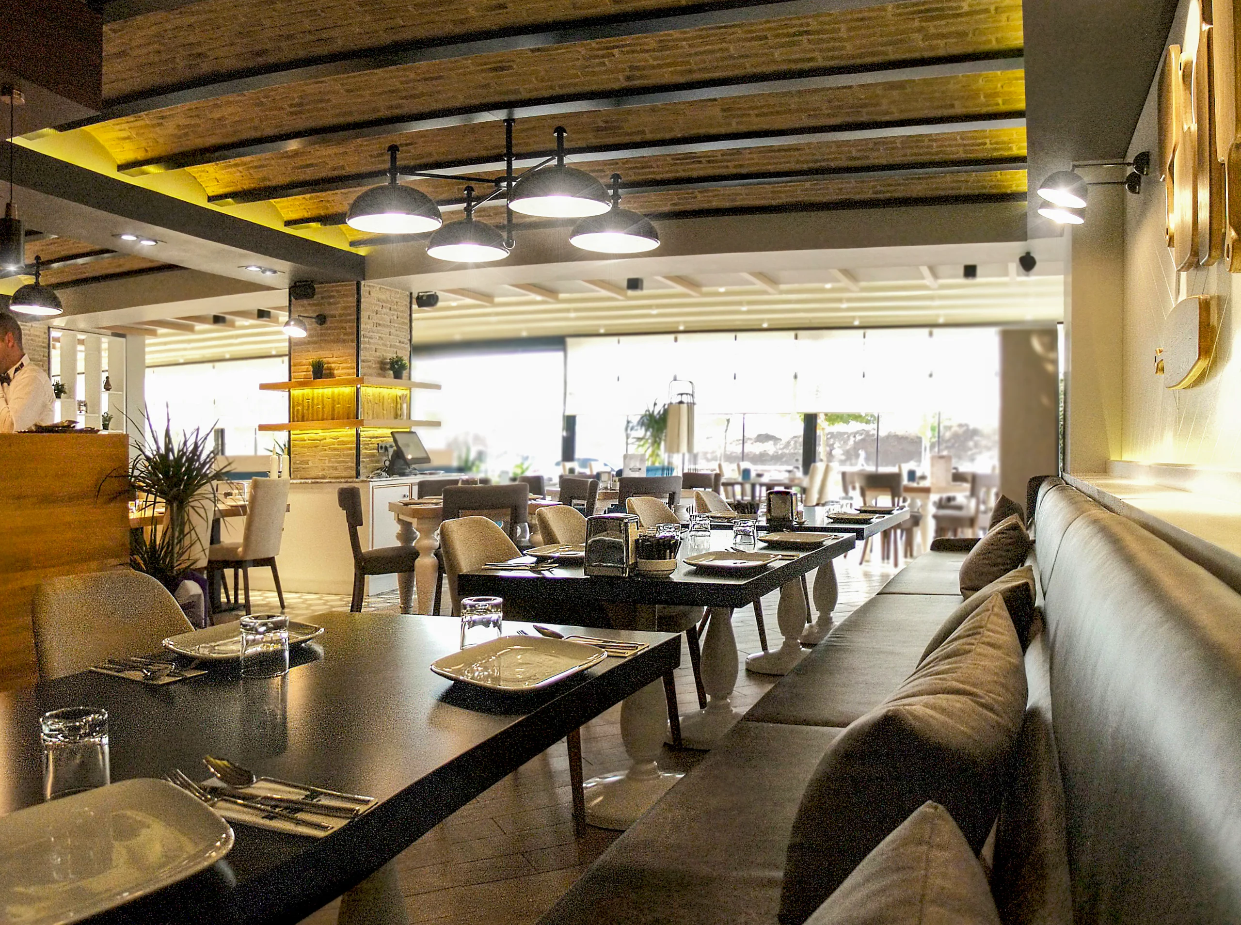 Fırın-ci 75 İlk Konsept iç mekânında ahşap banko, mermer yüzeyler, siyah metal detaylar ve sıcak restoran atmosferi.