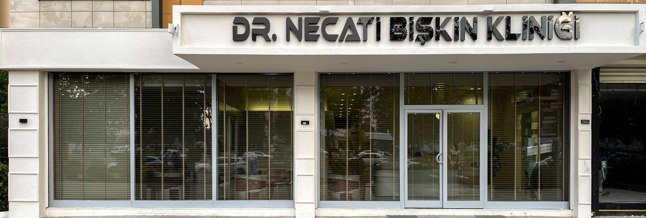 Doktor çalışma masası yakından görünüm, dekoratif yüz heykelleri, şık ziyaretçi koltukları ve duvarda asılı diplomalar, Mimar Nazlı Deniz Ozan Çifçi