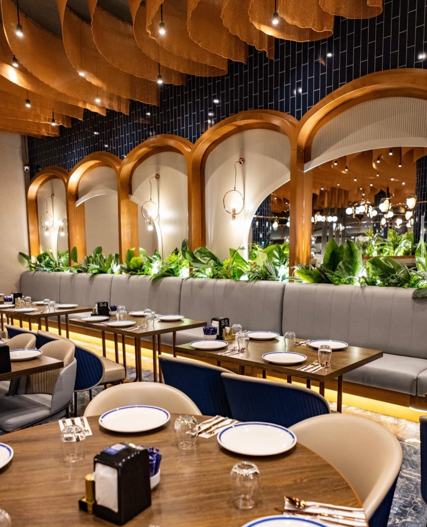 Evar Diyarbakır iç mekânında lacivert seramik yüzeyler, bakır aydınlatmalar ve bitkisel restoran atmosferi.