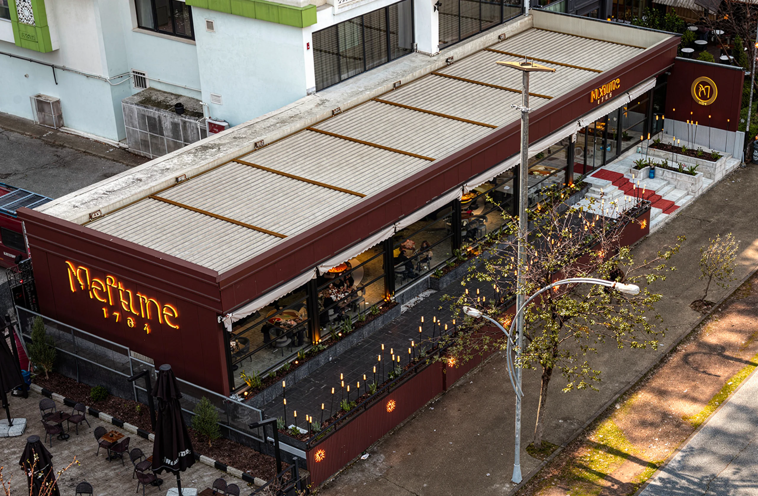 Restoranın genel oturma planı, deri ve kumaş sandalyeler, dairesel masalar ve botanik ögelerle desteklenmiş iç mimari, NDO Mimarlık
