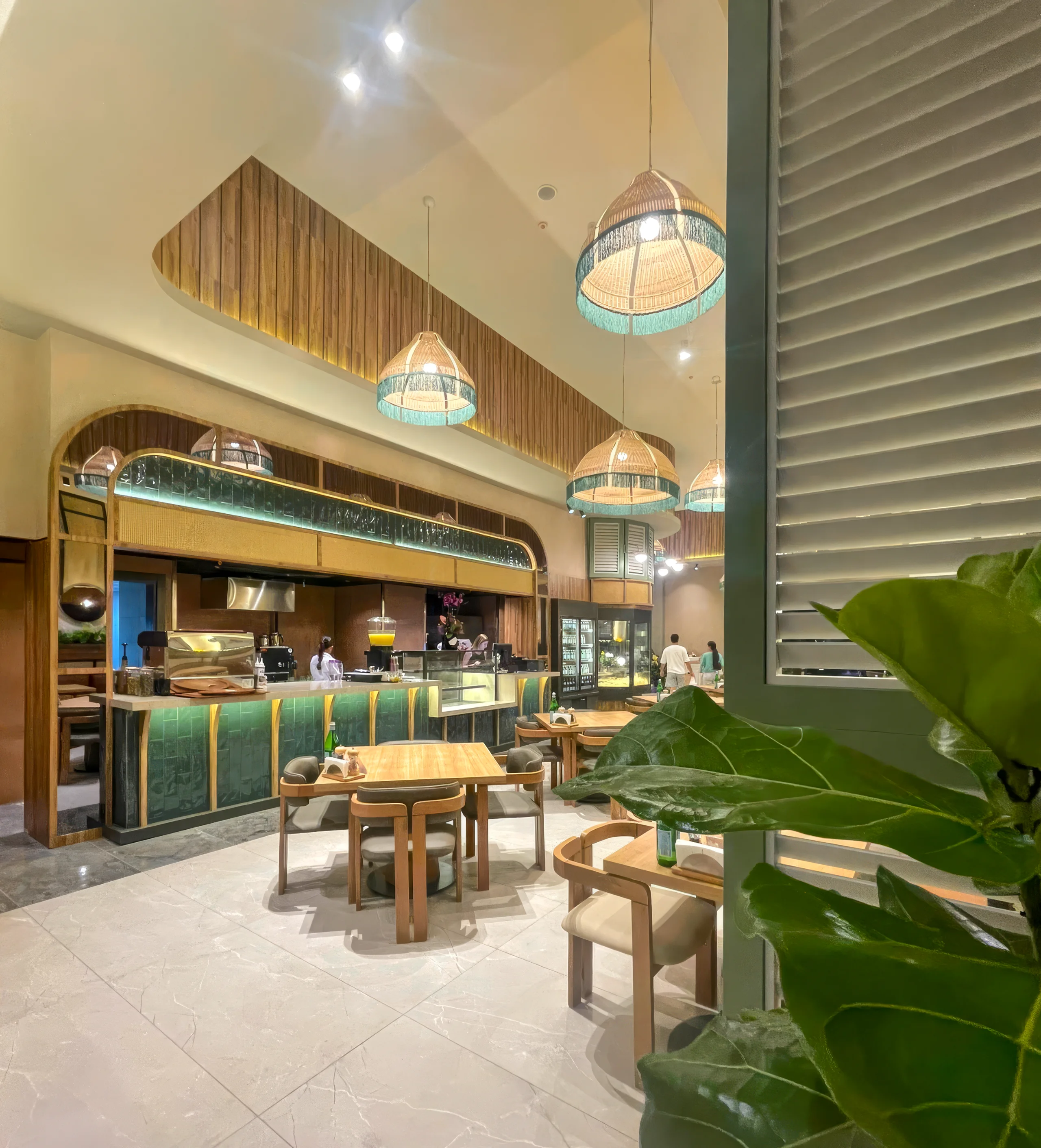 Niyokki Diyarbakır restoranında rattan detaylar, yeşil renk paleti ve sıcak aydınlatmayla tasarlanan oturma düzeni.