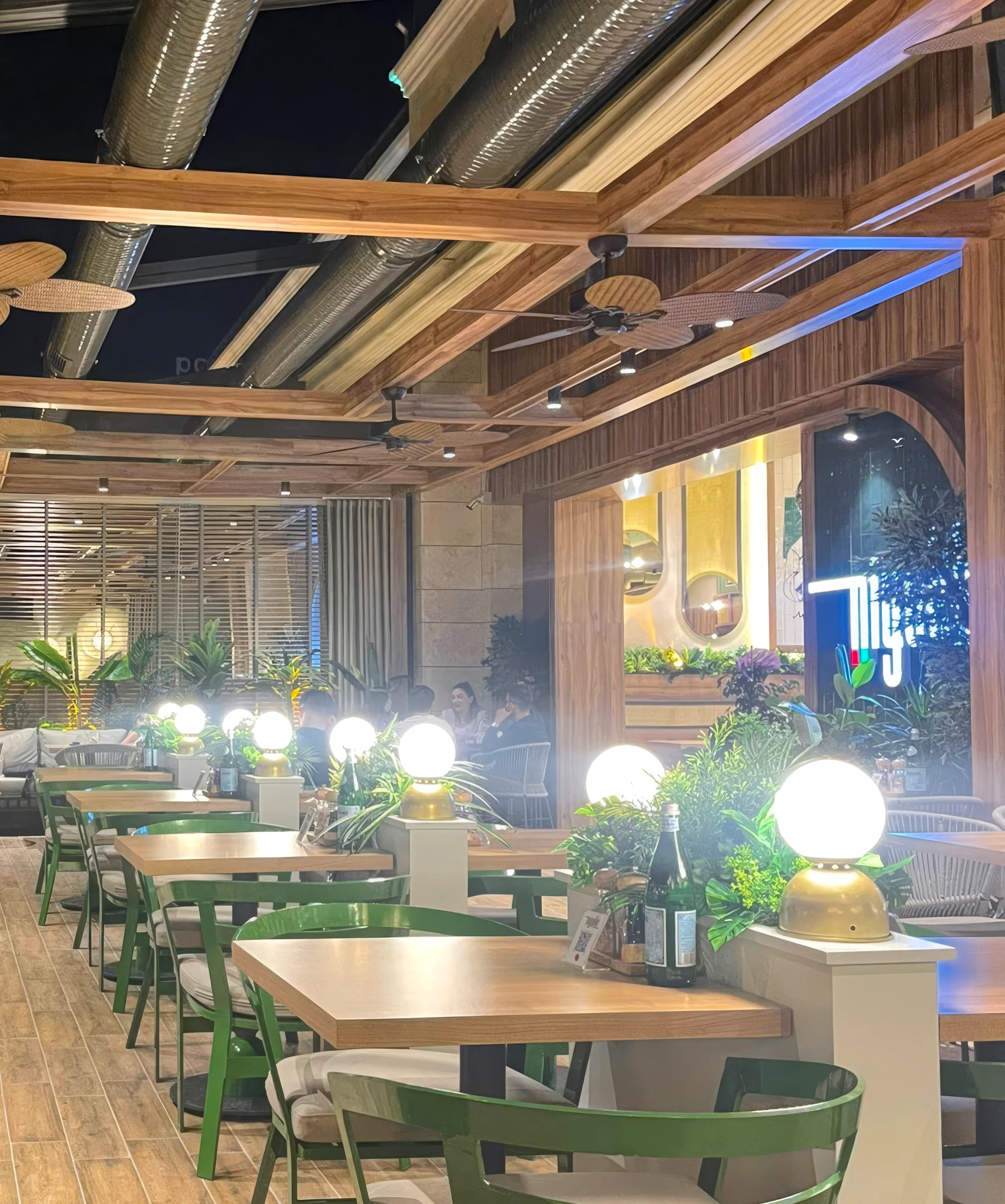Niyokki Diyarbakır iç mekânında rattan sandalyeler, ahşap masa düzeni ve Akdeniz etkili restoran tasarımı.