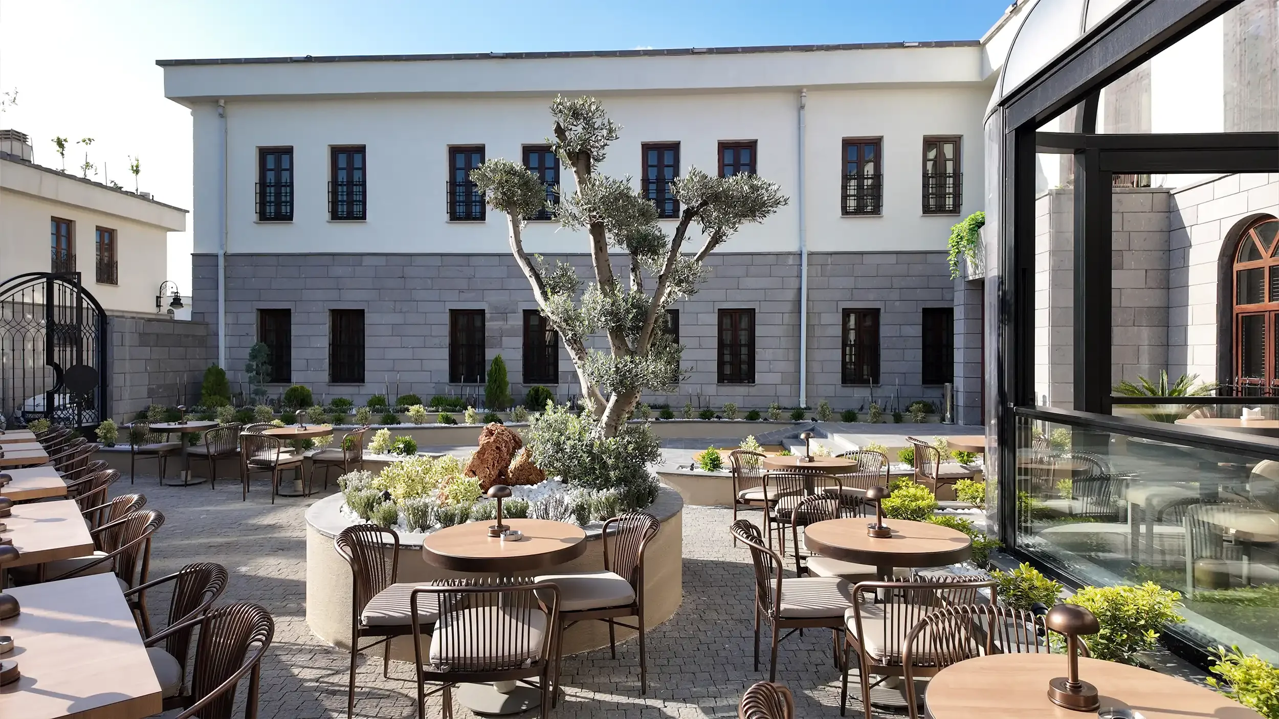 Rempart Hotel lobisinde kavisli resepsiyon bankosu, düşey koyu duvar panelleri, kemerli geçişler ve doğal ışıkla tasarlanan çağdaş butik otel karşılama alanı, NDO Mimarlık