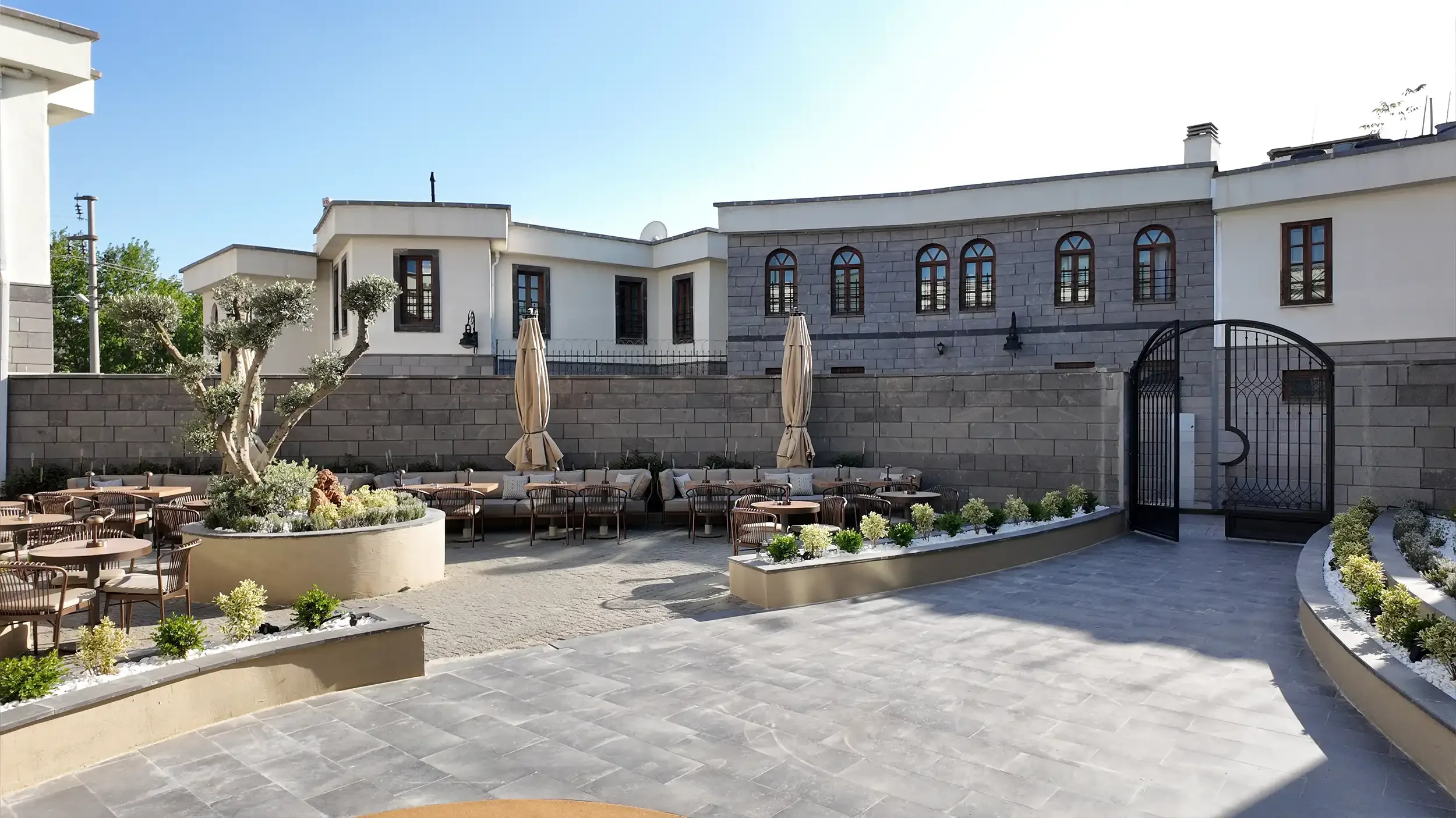 Rempart Hotel lobi alanında kemerli niş, sıcak gizli aydınlatma, büyük saksı bitkileri, modern bekleme koltukları ve dokulu duvar panelleriyle oluşturulan rafine atmosfer, NDO Mimarlık