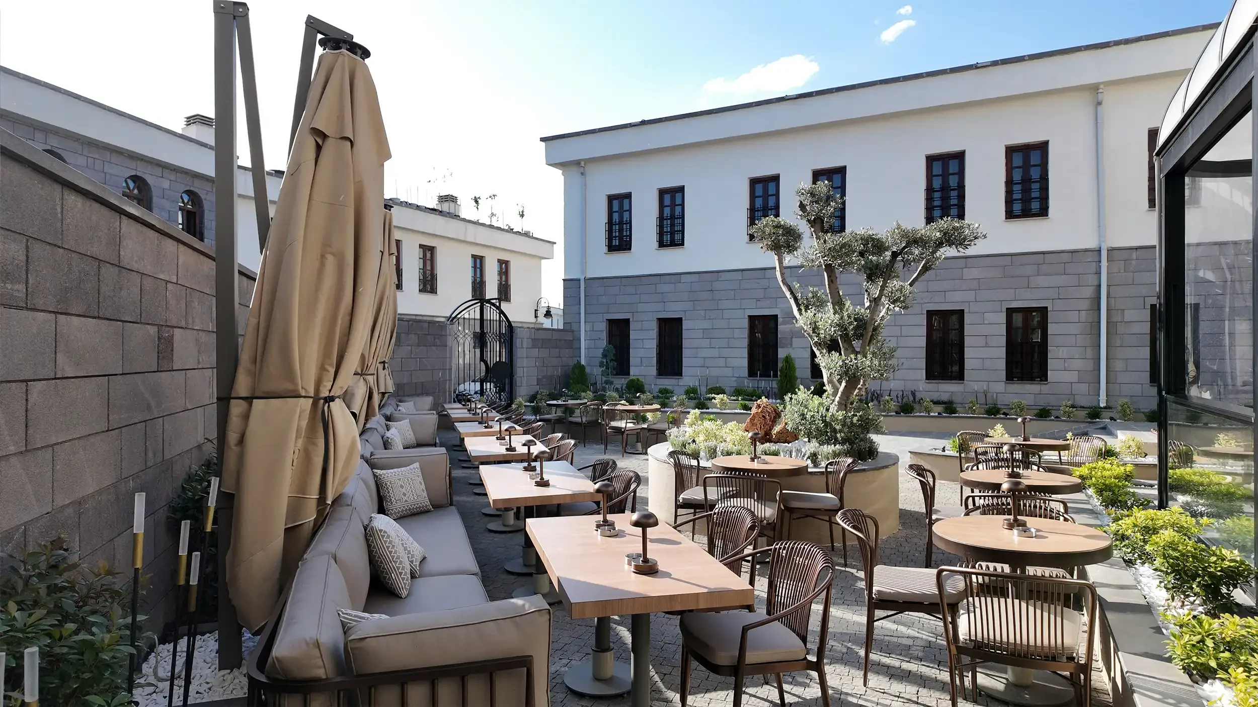 Rempart Hotel giriş lobisinde yüzer basamaklı merdiven, cam korkuluk, iç bahçe, küre aydınlatmalar ve lineer ışık detaylarıyla tasarlanan heykelsi merdiven alanı, NDO Mimarlık