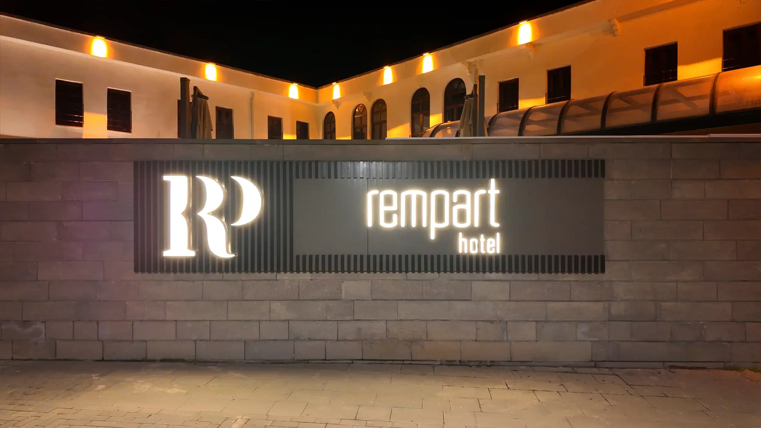 Rempart Hotel avlu cephesinde tarihi taş duvarlar, ahşap doğramalı kemerli pencereler, bitkisel peyzaj ve otel giriş aksıyla kurgulanan Sur Diyarbakır butik otel mimarisi, NDO Mimarlık