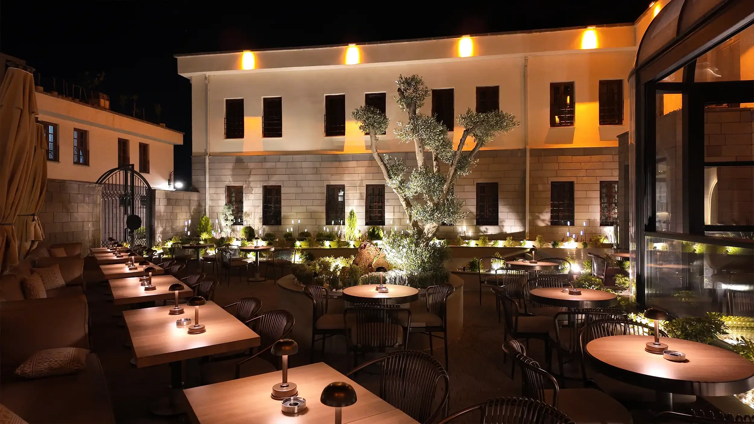 Rempart Hotel lobi geçişinde ardışık kemerler, mozaik zemin, sıcak tavan dokusu ve doğal bitkilerle tasarlanan çağdaş butik otel iç mekân aksı, NDO Mimarlık