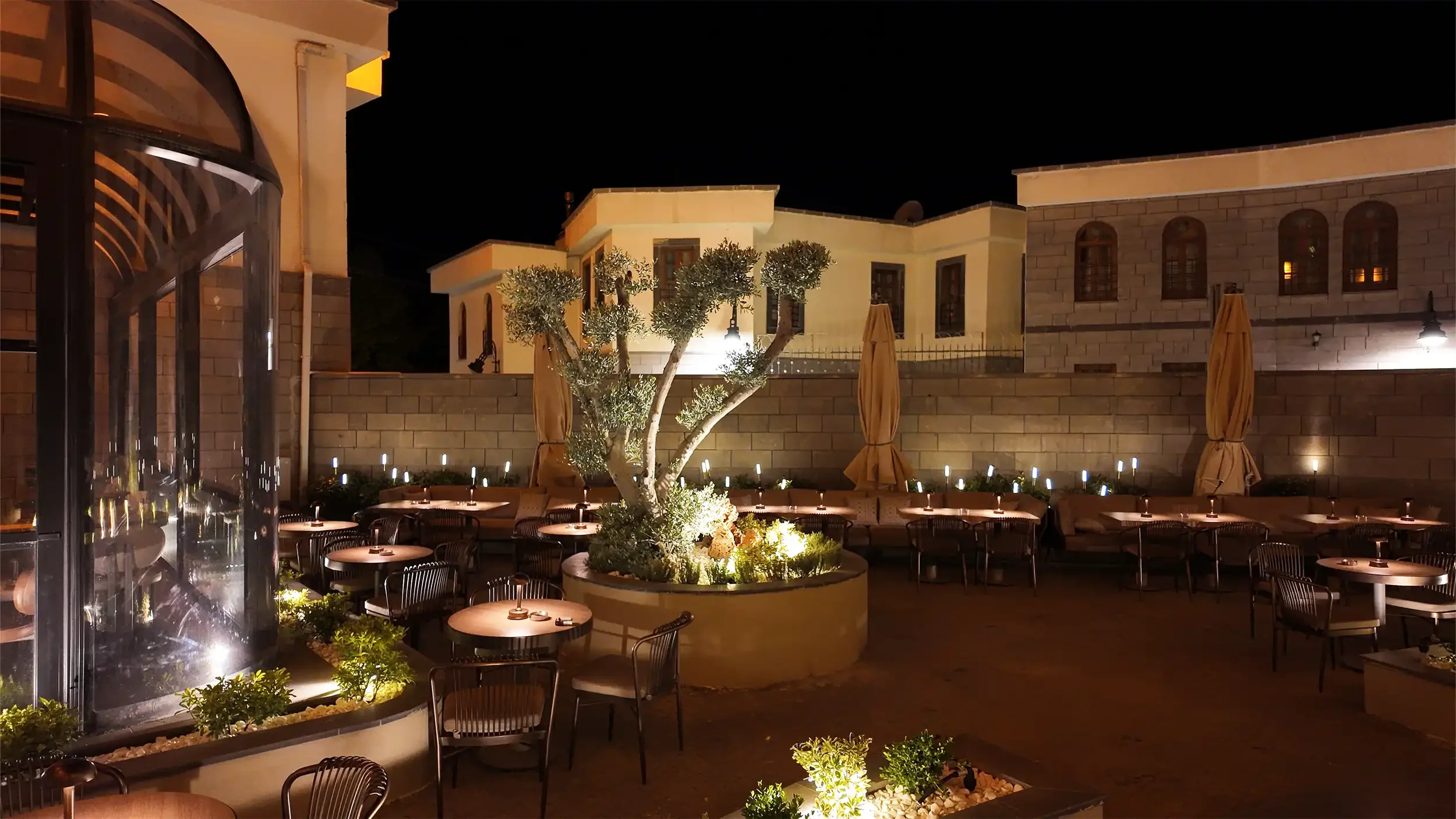 Rempart Hotel merdiven altında iç bahçe, doğal taş dokusu, bitkisel kompozisyon ve küre ışıklarla tasarlanan otel lobi odak noktası, NDO Mimarlık iç mimari projesi