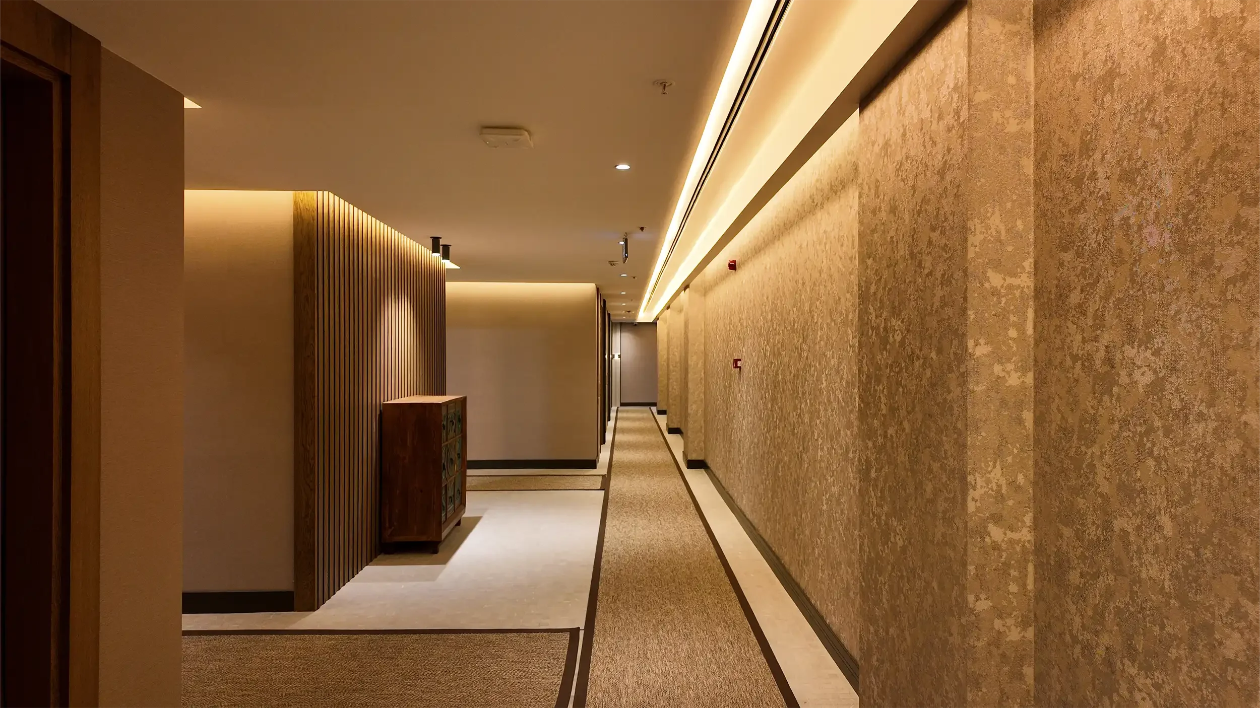 Rempart Hotel yatak odasında dokulu taş panel, sıcak gizli aydınlatma, kemerli başlık formu ve ahşap yüzeylerle kurgulanan modern butik otel odası, NDO Mimarlık