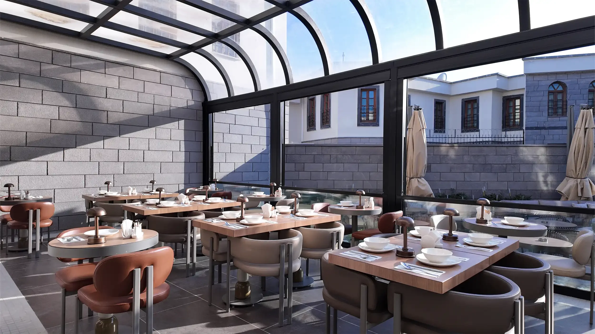 Rempart Hotel avlusundan giriş cephesine bakışta gri taş merdivenler, ahşap doğramalı kapı, kemerli pencere düzeni ve peyzaj sınırlarıyla tasarlanan butik otel girişi, NDO Mimarlık