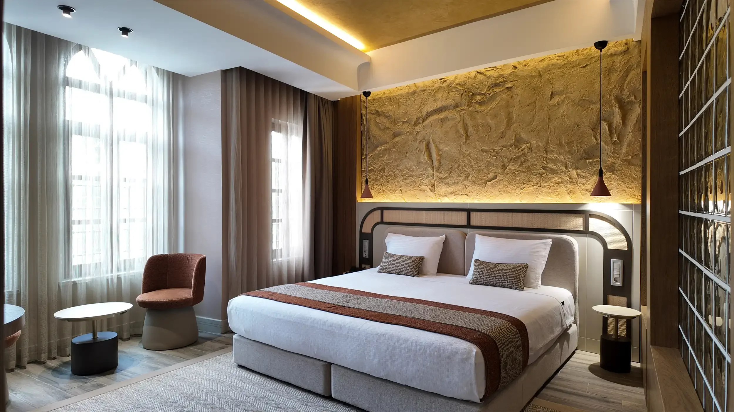 Rempart Hotel tarihi avlusunda beyaz cepheler, taş kaplama yüzeyler, ahşap pencere doğramaları ve siyah ferforje detaylarla korunmuş yerel mimari karakter, NDO Mimarlık