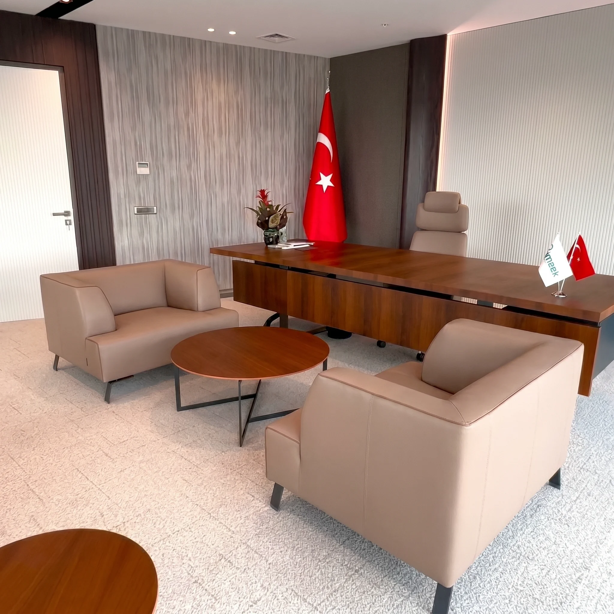 Mahall Ankara ofis projesinde şeffaf cam bölücüler, koyu ahşap kapı çerçeveleri ve gri halı dokusuyla tasarlanan modern idari ofis geçiş alanı, NDO Mimarlık